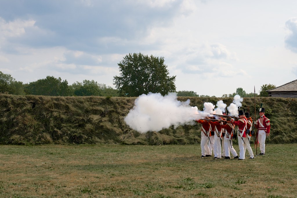 Niagara on the Lake, Ontario, Canada - August 29, 2015: A squad of soldiers demonstrate the firing of the traditional British Brown Bess musket to visitors to the Fort George Historic Site.