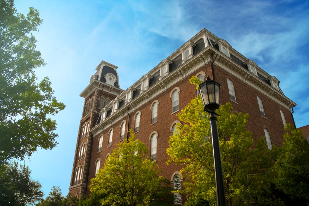Tilted up view of Old Main building on University of Arkansas campus against a blue sky in Fayetteville Arkansas
