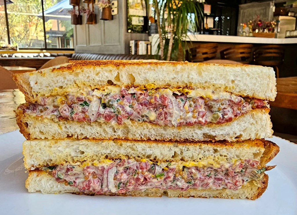 A sandwich cut in half with beef tartar.