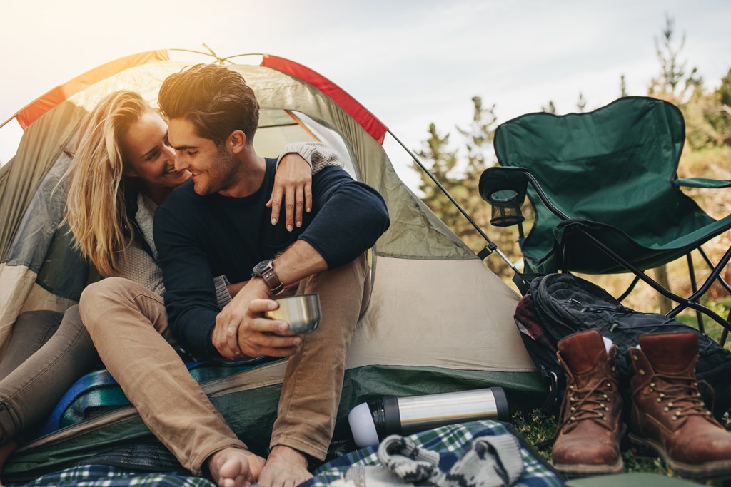 A happy couple enjoying tent camping at a KOA campground.
